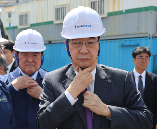 한덕수 대통령 권한대행 겸 국무총리가 16일 HD현대중공업 울산 조선소에서 시찰에 앞서 안전모를 착용하고 있다.<연합뉴스 사진>